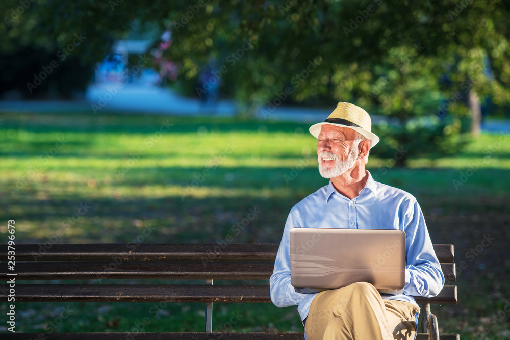 Senior man using laptop computer at rest in the park outdoors Senior man using laptop computer at rest in the park outdoors