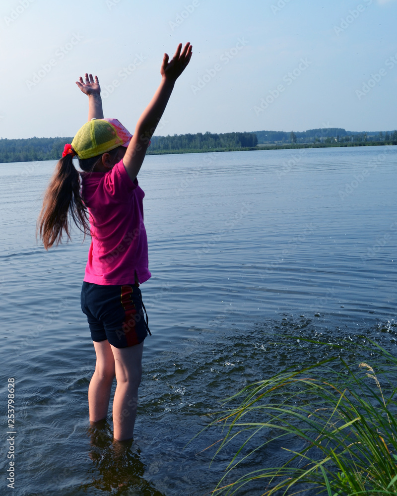 Joyful girl in the lake with splashes