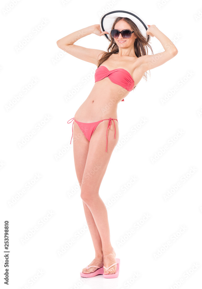 Fototapeta premium Bikini vacation holidays young woman standing, isolated on white background in studio, full body length. Happy girl in bikini swimsuit, sunglasses and sun hat.