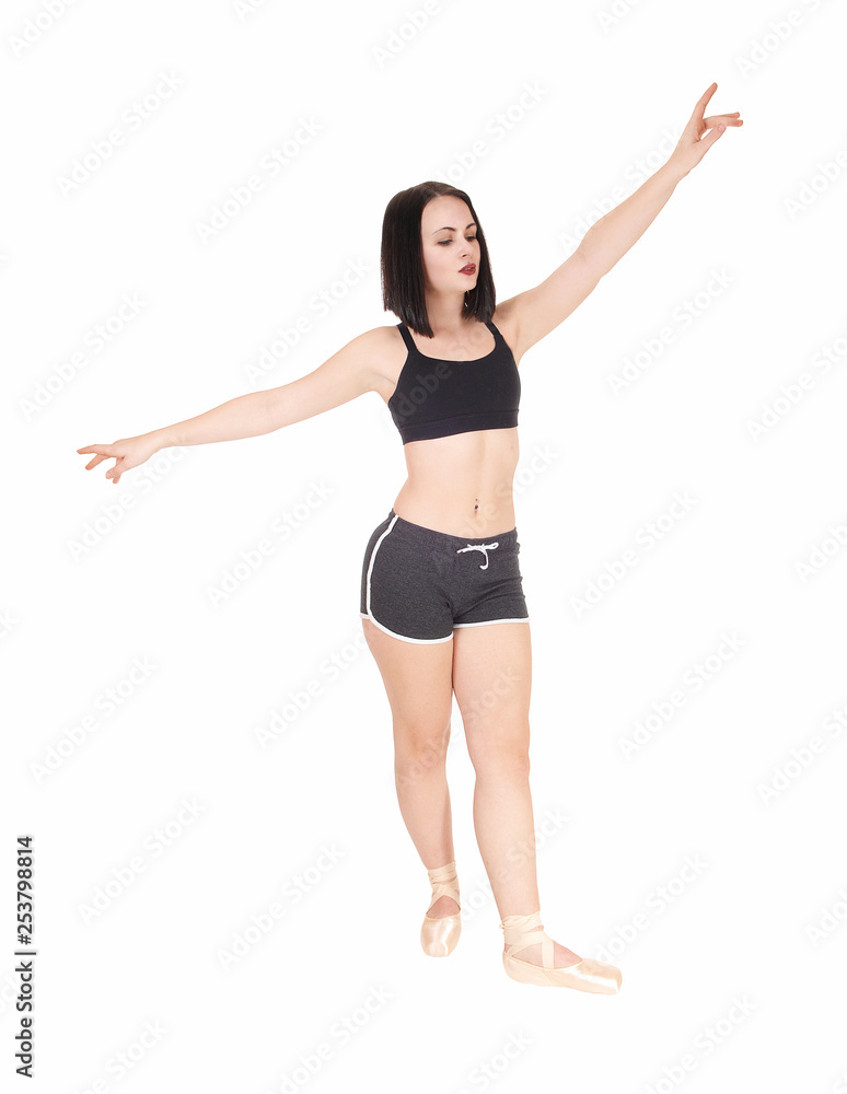 Dancing young woman standing hands raised in shorts