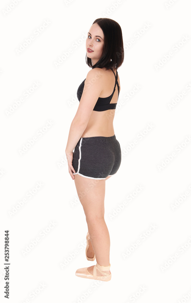 Young woman standing in black shorts in profile Young woman standing in black shorts in profile