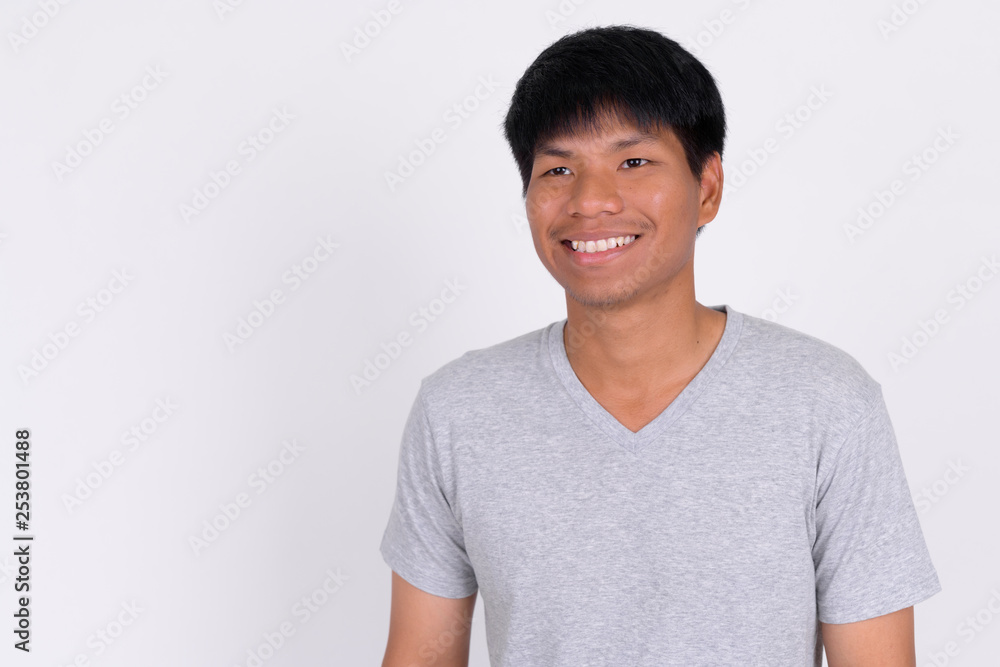 Portrait of happy young Asian man thinking and looking up Portrait of happy young Asian man thinking and looking up