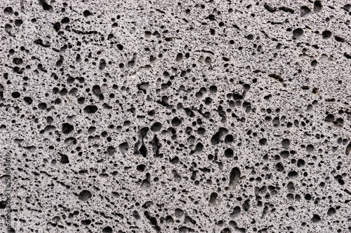 Closeup of gray porous stone textured wall. Stone background