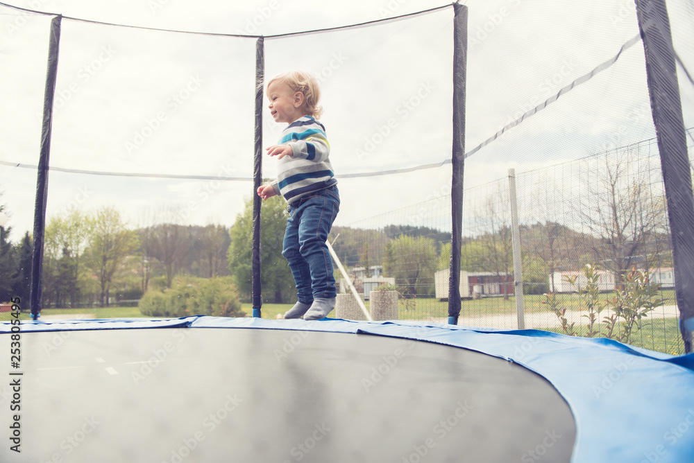 Beautiful little boy jumping on the trampoline outdoor. Beautiful little boy jumping on the trampoline outdoor.