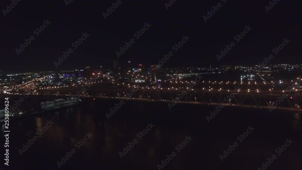 Wide aerial panning shot of cars traveling on the Lake Pontchartrain Bridge in New Orleans during night time and a view of the city lights in the background. Wide aerial panning shot of cars traveling on the Lake Pontchartrain Bridge in New Orleans during night time and a view of the city lights in the background.