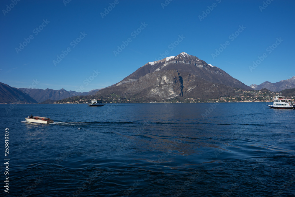 Italy, Menaggio, Lake Como, a large body of water with a mountain in the background
