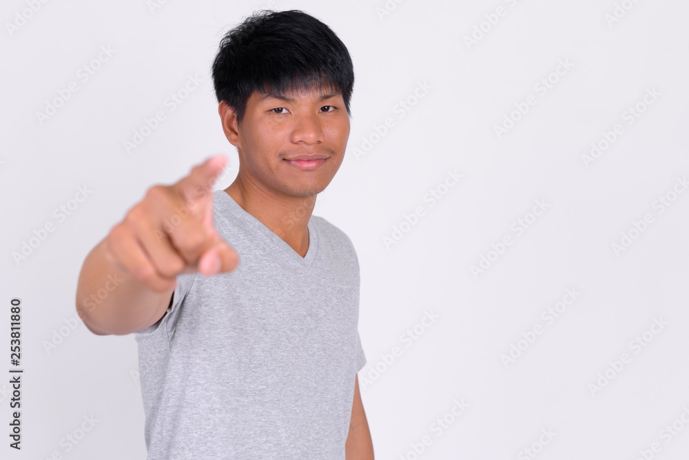 Portrait of young Asian man pointing at camera