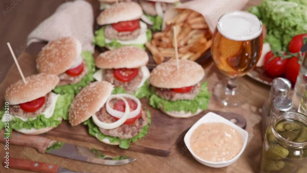 Logo shot camera movement from above showing a plateau of burgers. From blur to focused food composition of burgers, french fries and a glass of beer. Logo shot camera movement from above showing a plateau of burgers. From blur to focused food composition of burgers, french fries and a glass of beer.