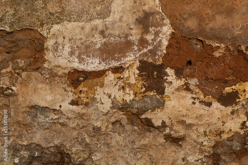 Obraz na plátne Layers of various colours of plaster crack away from a brink wall, great for wal