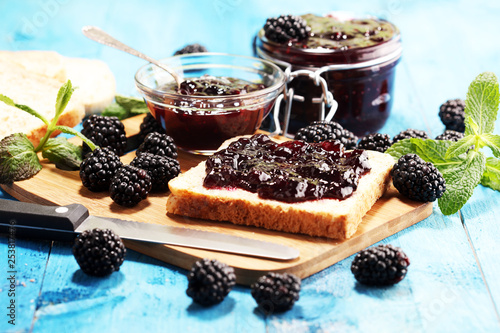 Toast bread with homemade blackberry jam or marmalade on table served with butter for breakfast or brunch