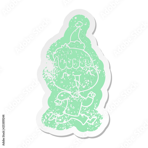 cartoon distressed sticker of a happy boy surprised wearing santa hat