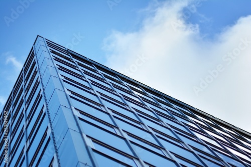 Surface of glass building with the reflection of clouds