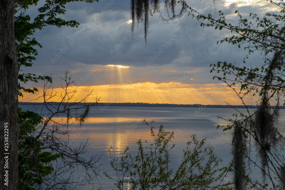 Evening Sun Peeking through Clouds from Shore of the St Johns River Florida Evening Sun Peeking through Clouds from Shore of the St Johns River Florida
