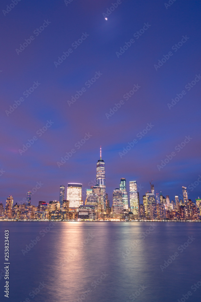 Financial District from Hudson river with half moon at twilight,long exposure