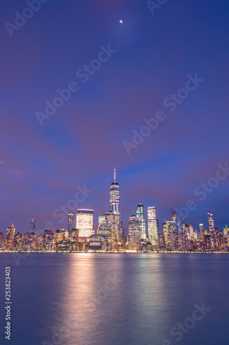 Financial District from Hudson river with half moon at twilight long exposure