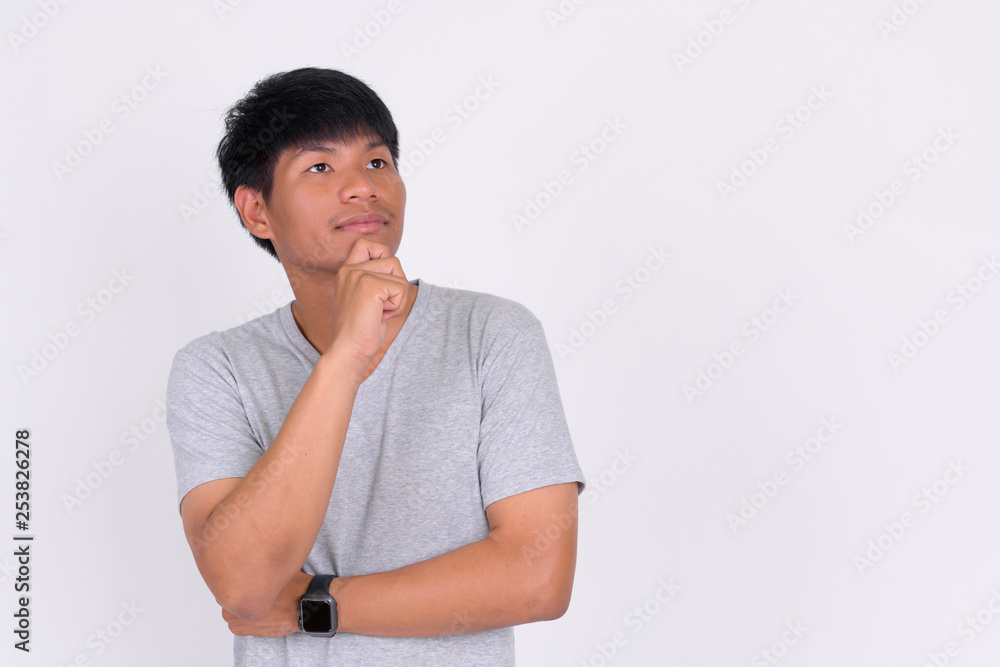 Portrait of young Asian man thinking and looking up Portrait of young Asian man thinking and looking up