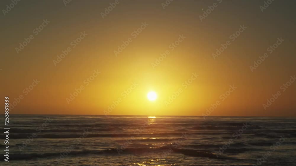 Time lapse of the sun disappearing on the horizon with waves reaching the beach. Time lapse of the sun disappearing on the horizon with waves reaching the beach.