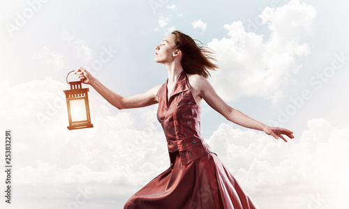 Bild auf Leinwand Attractive girl muse with old lantern in hand at summer day