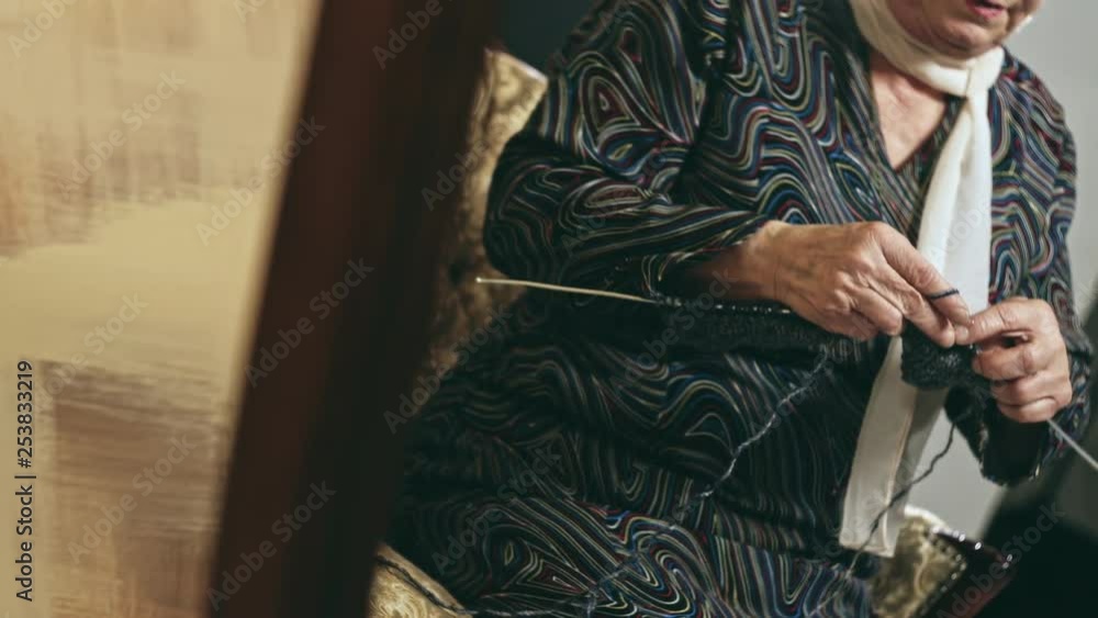 Elderly woman knitting and dancing near mirror Elderly woman knitting and dancing near mirror