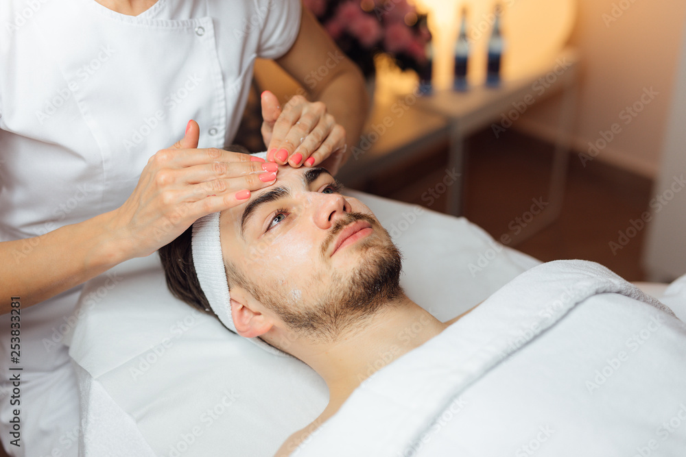 Unshaven man having cosmetic mask care in spa salon, side, top view - Image Unshaven man having cosmetic mask care in spa salon, side, top view - Image