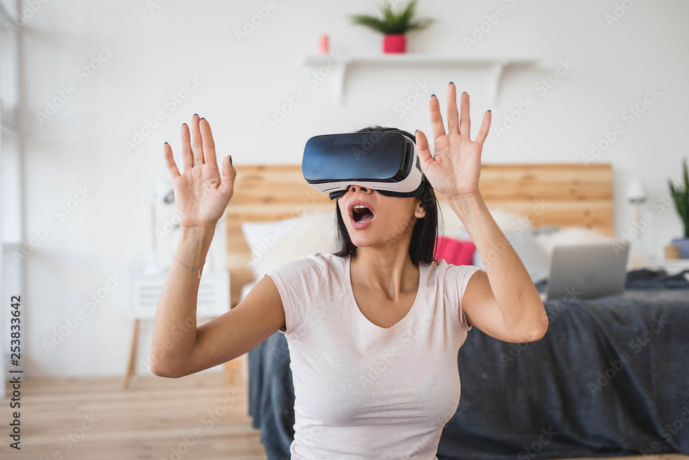 Portrait of smiling happy young woman getting experience using VR glasses at home Portrait of smiling happy young woman getting experience using VR glasses at home