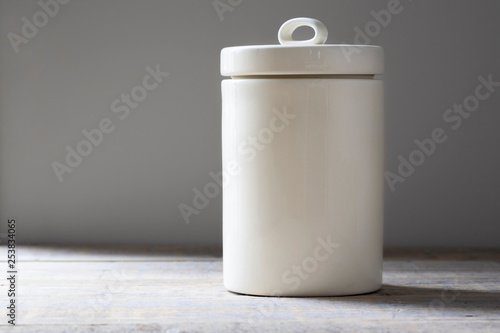 Photography Mockup of a cream ceramic food storage canister on a wooden table