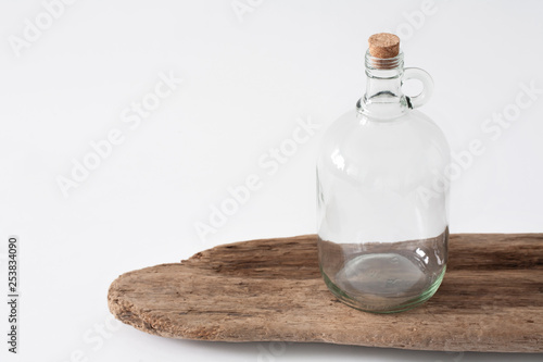Mockup of a large empty glass growler bottle on a white table.