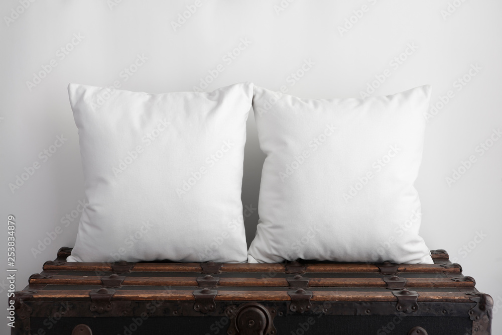 Mockup of two large white square cushions sitting on an old vintage suitcase - obrazy, fototapety, plakaty 