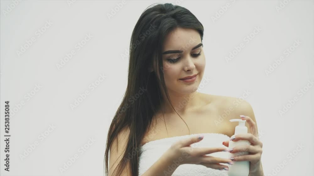 Close-up of a beautiful young girl with creamy lotion, which relates to her shoulder, feeling happy and cheerful for the moisture of her healthy skin, the concept of skin care. Close-up of a beautiful young girl with creamy lotion, which relates to her shoulder, feeling happy and cheerful for the moisture of her healthy skin, the concept of skin care.