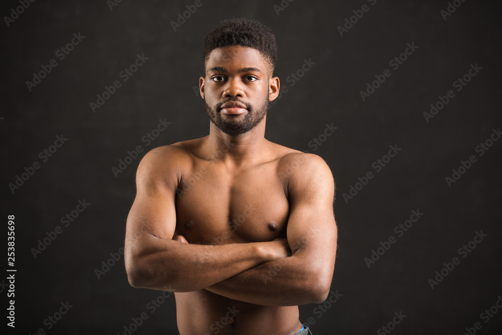 handsome african man with muscles on black background