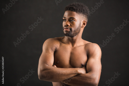 handsome african man with muscles on black background © Alexandr