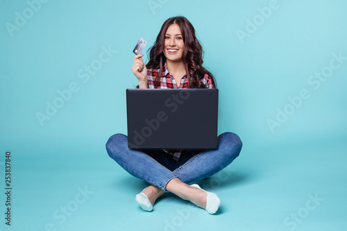 Pretty woman sitting with computer and making shopping online by credit card © burdun