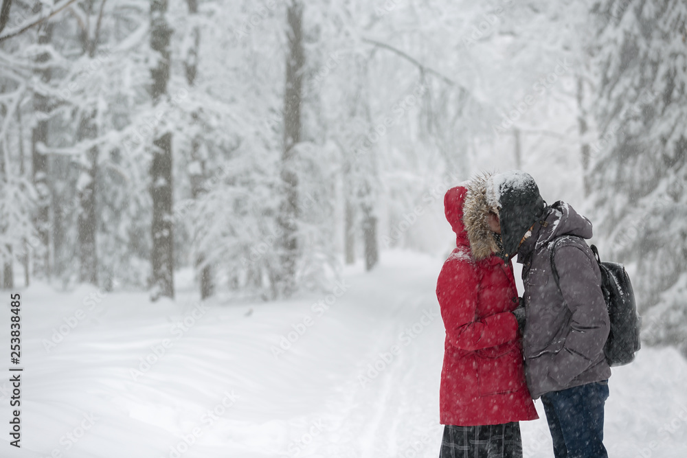 guy with the girl in the red jacket kisses on the street in a winter snowy day in Moscow guy with the girl in the red jacket kisses on the street in a winter snowy day in Moscow