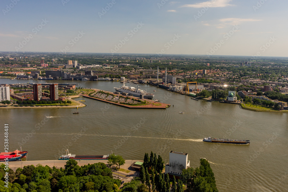 Netherlands, Rotterdam, a small boat in a body of water with a cityscape skyline in the background