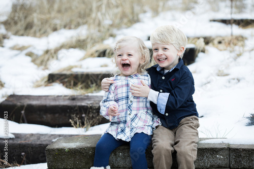 Young brother and sister laughing in winter