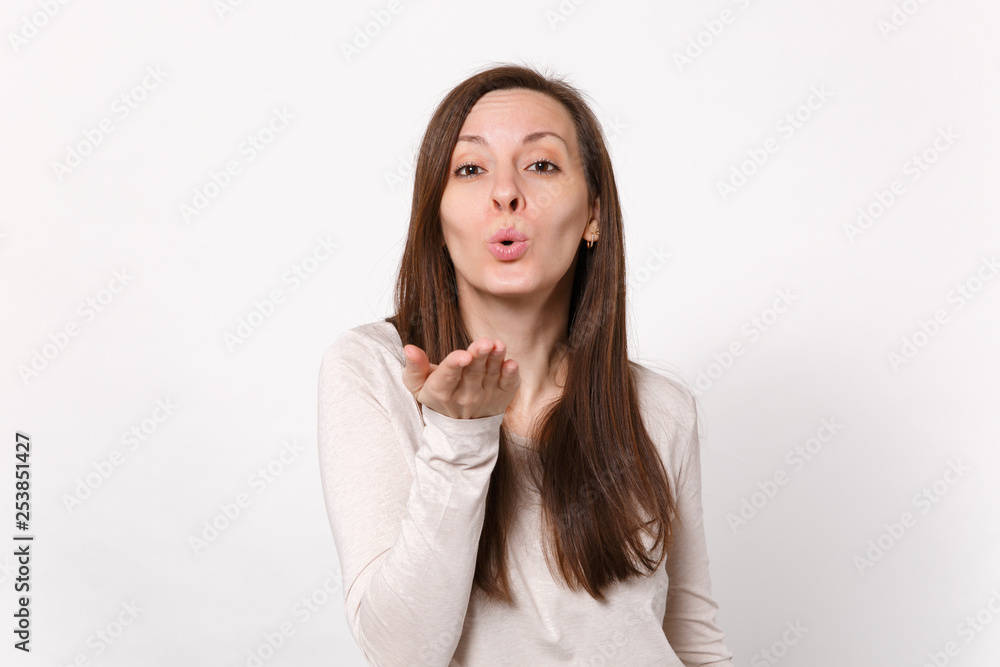 Portrait of pretty attractive tender young woman in light clothes blowing sending air kiss isolated on white wall background in studio. People sincere emotions, lifestyle concept. Mock up copy space. Portrait of pretty attractive tender young woman in light clothes blowing sending air kiss isolated on white wall background in studio. People sincere emotions, lifestyle concept. Mock up copy space.