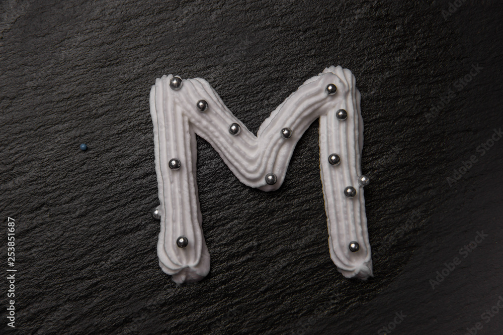 Whipped cream letters decorated with silver beads Whipped cream letters decorated with silver beads