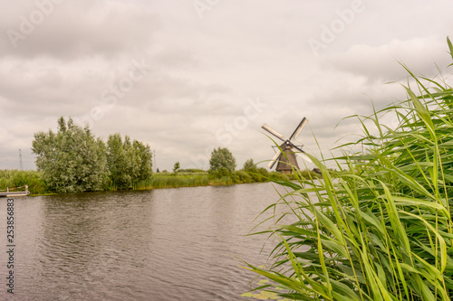Netherlands  Rotterdam  Kinderdijk  heritage windmill above lush green grass along a canal