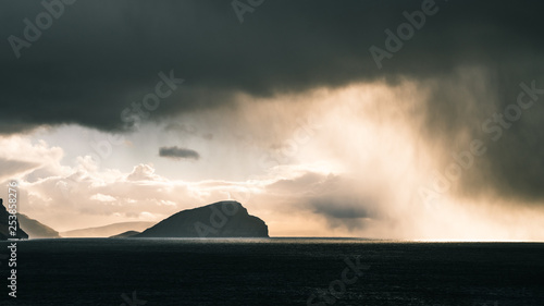 Rain clouds in the distance followed by sunlight  in the Faroe Islands photo