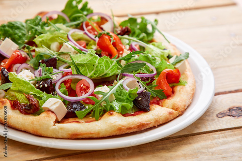 vegetarian pizza with fresh tomatoes, olives, tofu and red onion