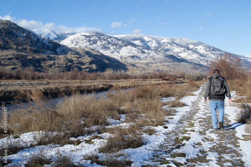 Male Hiker on Walking Trail with Snow on Mountains in Background, Okanagan Valley, British Columbia, Canada