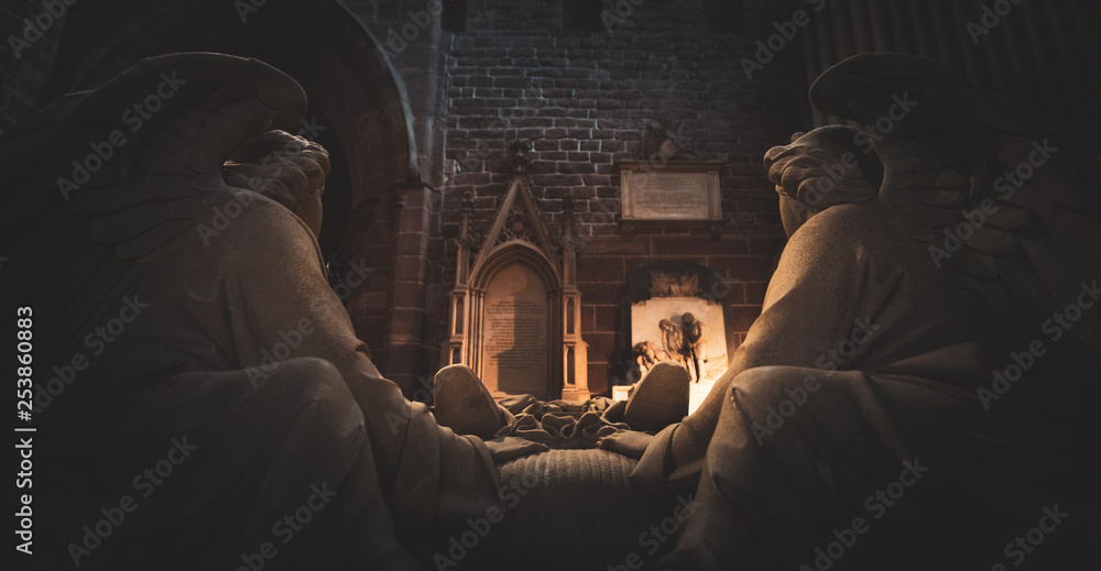 Two statues of angels sit overlooking a tomb in the Cathedral of Chester