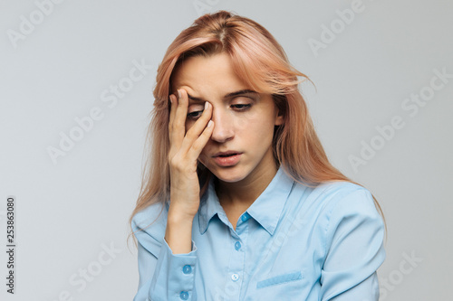 Displeased woman nearly falling asleep at work, hold her head with hand.Sleepy student spending time in university, feels lack of energy. Sleep deprivation, insomnia, apathy, weariness concept photo