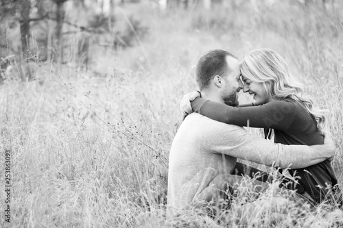 Photography Young happy couple embracing in grassy field