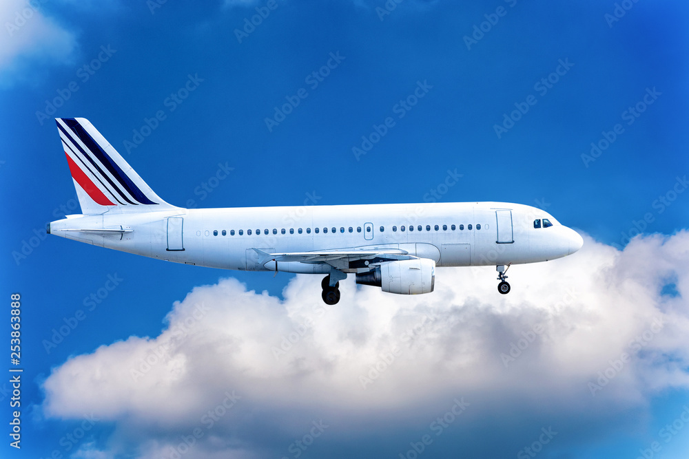 Obraz premium Big jet flying on background of cloudy blue sky.
