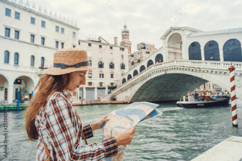 Discovery the Venice. Traveler girl looks at the map of walking, female adventure in Venice, Ponte di Rialto Italy