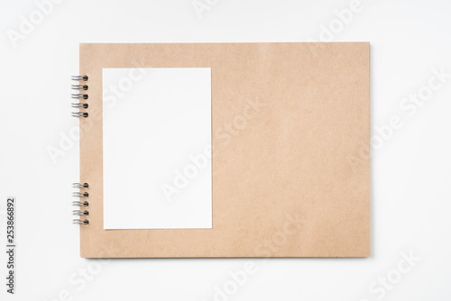 kraft notebook, photo frame and pen on white