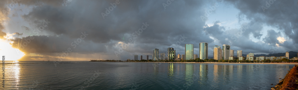 Fototapeta premium Amazing panoramic view of the Honolulu Skyline. A gorgeous sunset is seen on the horizon.