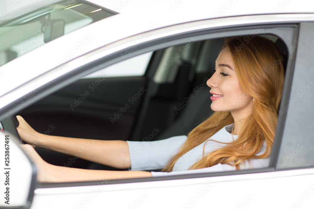 Happy young woman shopping for a new car