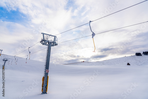 Empty Ski Lift in a Snowy Slope in the Alps on a Partly Cloudy Winter Day